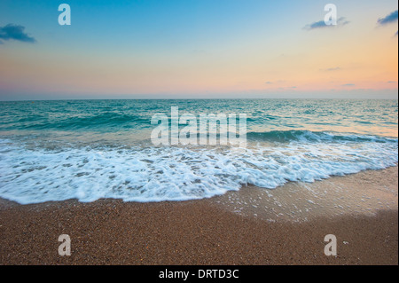 Meereswellen und Sandstrand in der Morgendämmerung Stockfoto