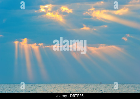 Strahlen der Sonne bricht durch die Wolken über dem Meer Stockfoto