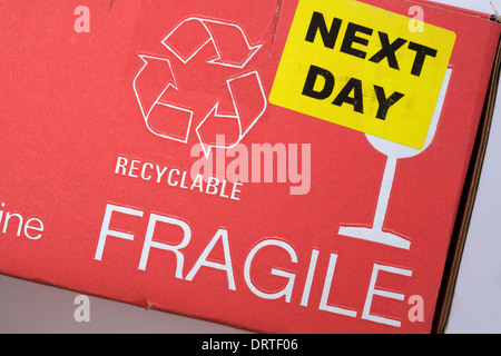 Aufkleber am nächsten Tag, recycelbares Logo und Informationen zu zerbrechlichem Glas auf der Kartonverpackung – Symbol für das Recycling-Logo Stockfoto