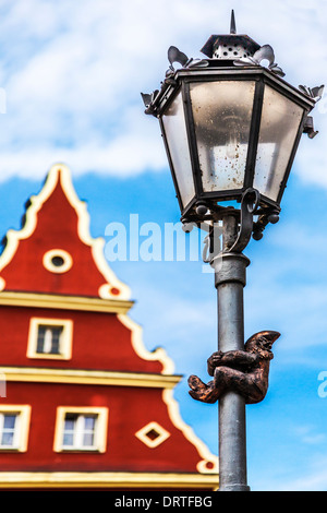 Einer der Breslauer berühmte kleine Bronze-Zwerge, Zwerge oder Krasnale Statuen Klettern eine Straßenlaterne in der Altstädter Markt. Stockfoto