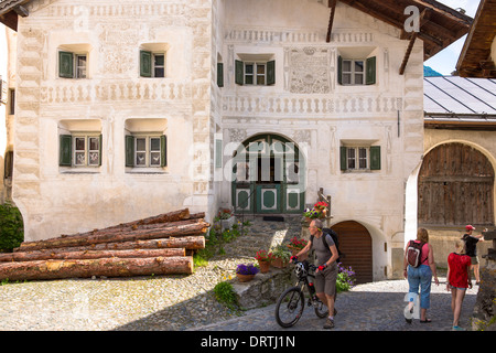Touristen gehen Pension Val Tuoi im Engadin im Dorf Guarda mit bemalten 17. Jahrhundert Häusern aus Stein, Schweiz Stockfoto