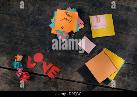 Anpassbare Botschaften der Liebe und Wertschätzung mit Post-Its auf einem Vintage Holztisch. Stockfoto