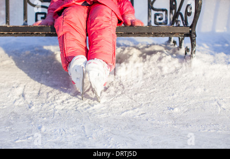 Nahaufnahme von kleinen Skater Beinen stehend auf Winter Eisbahn Stockfoto