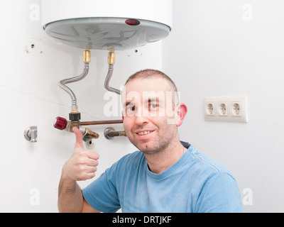 Klempner Menschen positive Emotionen mit ok Symbol mit der Hand. Mann hat einen elektrischen Boiler repariert. Stockfoto
