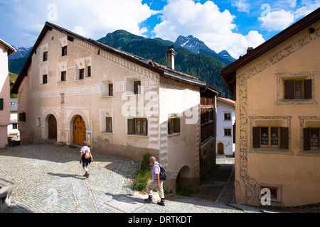 Touristen-Spaziergang im Engadin im Dorf Ardez mit bemalten Stein 17. Jahrhundert restaurierte Häuser, Schweiz Stockfoto