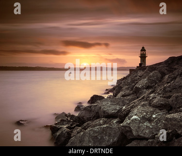 Brixham Leuchtturm am Ende der Mole bei Sonnenuntergang. Stockfoto