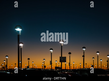 Der strahlende orangefarbene Schein der Dämmerung bemalt den Abendhimmel über dem Parkdeck am Atlanta International Airport. (USA) Stockfoto