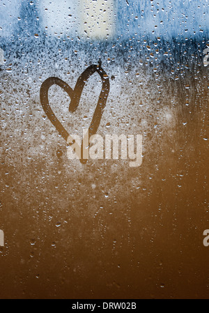 Herz auf Glas gemalt. Das Glas ist beschlagen und es gibt viele Tropfen auf Sie Stockfoto