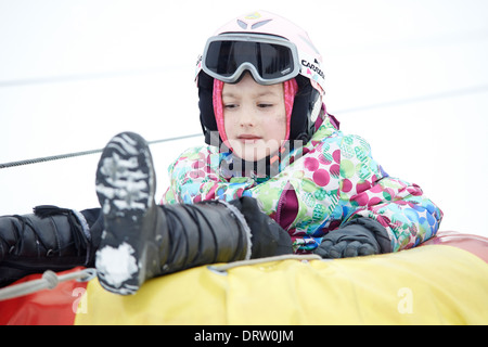 Kind Mädchen genießen Snow Tubing Stockfoto