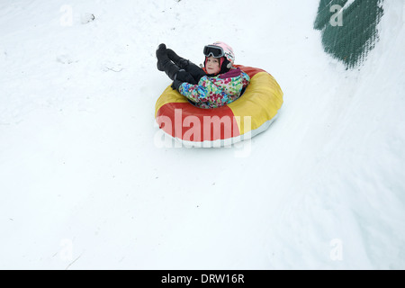 Kind Mädchen genießen Snow Tubing Stockfoto