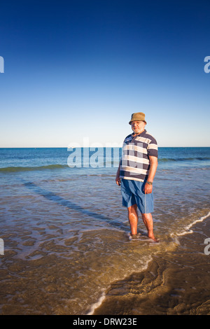 Senior woman walking am Strand Stockfoto