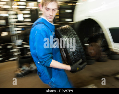 Kfz-Mechaniker ändert ein Rad eines Autos. Stockfoto