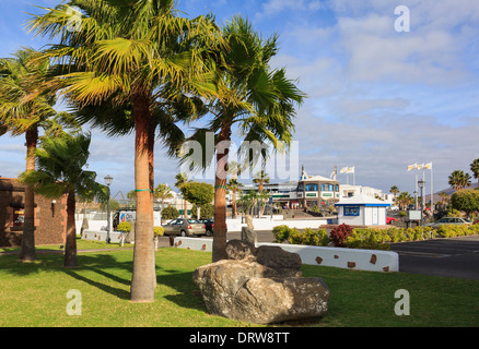 Palmen und Gärten in gehobenen Urlaubsort an der Küste von Marina Rubicon, Playa Blanca, Lanzarote, Kanarische Inseln, Spanien Stockfoto