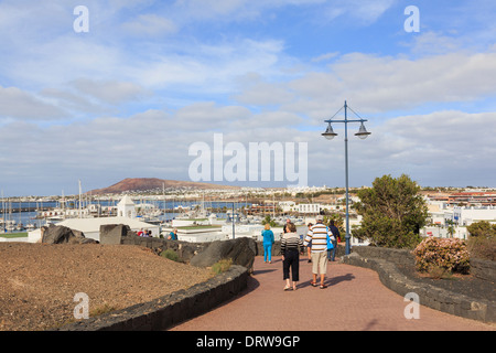 Menschen, die ein Spaziergang entlang der Strandpromenade promenade in gehobenen Resort Marina Rubicon, Playa Blanca, Lanzarote, Kanarische Inseln, Spanien Stockfoto