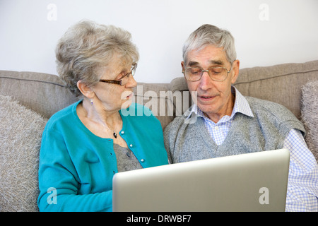 Älteres paar-Sitzung mit einem Laptop zu Hause. Stockfoto