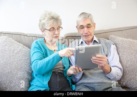 Älteres Paar mit einem digitalen Tablet zu Hause. Stockfoto