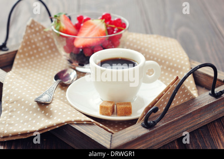 Tasse Kaffee mit frischen Beeren auf Vintage Holztablett closeup Stockfoto