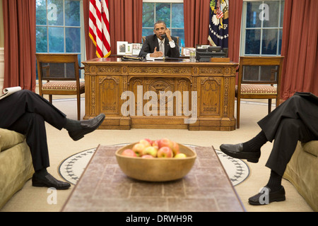 US-Präsident Barack Obama spricht am Telefon mit Bundeskanzlerin Angela Merkel Deutschland, Syrien aus dem Oval Office des weißen Hauses 29. August 2013 in Washington, DC zu diskutieren. Stockfoto