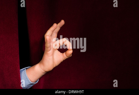 Hand-Symbol des Erfolgs. Roter Vorhang Hintergrund Stockfoto