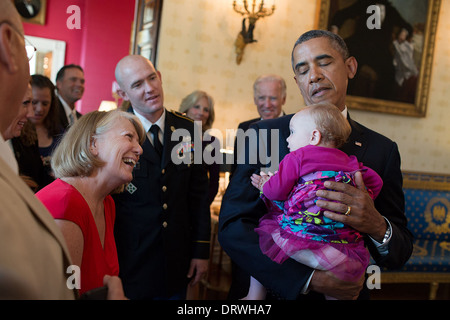 US-Präsident Barack Obama besucht mit US Army Staff Sergeant Ty Carter und Familie im Blue Room des weißen Hauses vor die Medal Of Honor Zeremonie zu Ehren Carter 26. August 2013 in Washington, DC. Der Präsident hält Carters Tochter Sehara. Stockfoto