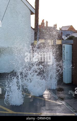 Meerwasser durch Abfluss wogenden deckt auf dem Parkplatz am Watchet Hafen bei Flut während der Winterstürme. Stockfoto