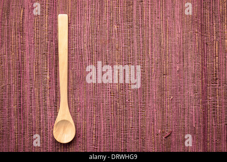 Holzlöffel auf eine bunte violett Textil Stockfoto