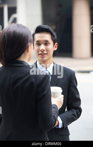 Glücklich chinesischen Geschäftspartnern außerhalb des Büros miteinander zu reden. Stockfoto