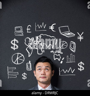 Chinesischer Geschäftsmann vor eine Skizze oder ein Diagramm über Wirtschaft und Handel Stockfoto