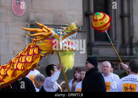 Chinesische Kostüm Tierkreis Tiere. Traditionelles goldenes Neujahrstanzfest in Chinatown 2nd. Februar 2104. Menschen beobachten den Tanz des Hochpol-Drachens beim chinesischen Neujahr auf dem Albert Square in Manchester, dem größten chinesischen Neujahrsfest des Nordens. Die Chinatown von Manchester ist eine der größten Europas, die sich in einem engen Straßenraster hinter den Piccadilly Gardens befindet. Mit einem 175 Meter langen Papierdrachen, einem Löwentanz und Kampfkunstvorführungen ist die Dragon Parade einer der Höhepunkte des jährlichen Veranstaltungskalenders von Manchester. Stockfoto