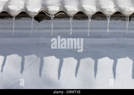 Eiszapfen am Dach des Gebäudes Stockfoto