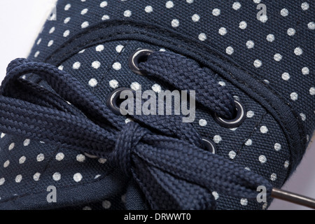 Schnürsenkel auf navy blue Polka Dots Canvas Schuh - Nahaufnahme Detail Stockfoto