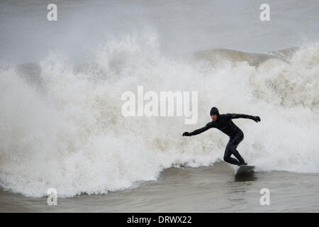 Aberystwyth Wales UK, Montag, 3. Februar 2014 unerschrockene Surfer nutzen Sie die riesige schwillt der Strand von Aberystwyth, Abbruch, nachdem ein Wochenende von stürmischem Wetter und Gale zwingen Winde, die Hunderte von Tonnen von Sand und Kies von den Wellen an der Küste gedumpt waren, und einige entstand Sachschaden an den Wänden außen Universität Studentenwohnheime. Einige 600 Studenten waren für das Wochenende evakuiert worden und wird nicht zurück bis heute Nachmittag gesagt.   Bildnachweis: Keith Morris/Alamy Live-Nachrichten Stockfoto