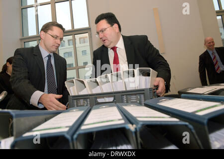 München, Deutschland. 3. Februar 2014. Andreas Tilip (R), Rechtsanwalt von der HRE Blei Petent und sein Partner Marc Schiefer (L) sind vor Dateien dokumentieren die Hypo Real Estate Aktie Verluste am Eröffnungstag der Sammelklage gegen Hypo Real Estate an das Oberlandesgericht in München, 3. Februar 2014 abgebildet. Kläger machen geltend, dass Milliarden-Entschädigung für Hypo Real Estate Verluste teilen. Der Prozess beginnt während der Finanzkrise mehr als fünf Jahre nach der milliardenschwere Bankenrettung der Hypo Real Estate. Foto: PETER KNEFFEL/dpa Stockfoto