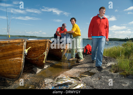 Angeln-Kumpels entladen ihre hölzernen Motorboot nach einem Tag voller Zander Angeln. Stockfoto