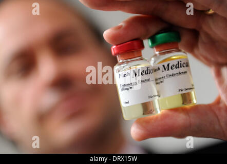 München, Deutschland. 3. Februar 2014. Leitender Staatsanwalt Kai Graeber präsentiert zwei Flaschen mit anabolen Steroiden auf einer Pressekonferenz in München, 3. Februar 2014. Die öffentlichen Proisecutor Büro- und bayerischen Staatsminister der Justiz präsentiert leistungssteigernde Mittel und einen Entwurf für ein neues bayerische Anti-doping-Gesetz. Foto: ANDREAS GEBERT/DPA/Alamy Live-Nachrichten Stockfoto