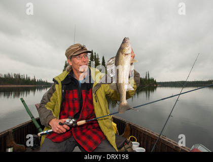 Angler hält eine große Sommer-Zander, die er von seinem Boot auf einem See im Norden von Ontario gefangen. Stockfoto