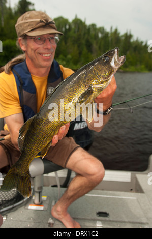 Angler hält eine große Sommer-Zander, die er von seinem Boot auf einem See im Norden von Ontario gefangen. Stockfoto