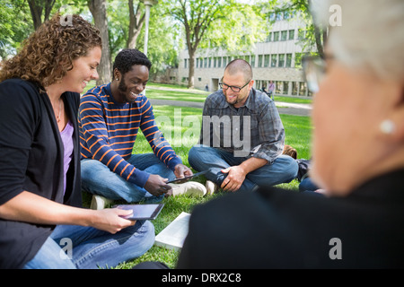 Gruppe von Studenten, die mit Digital-Tablette auf dem Campus Stockfoto