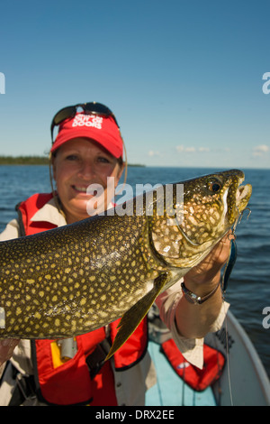 Frau Angler hält eine große Sommer-Seeforellen gefangen von einem Boot in einem See im Norden von Ontario. Stockfoto