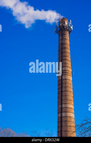 Rauchen gemauerten Turm mit mobilen Antenne gegen blauen Himmel Stockfoto