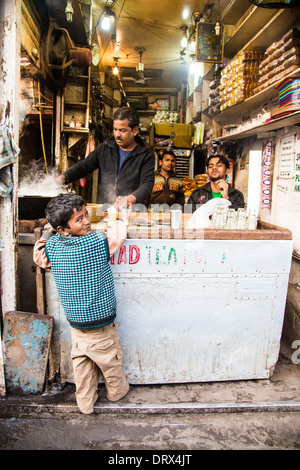 Junge Kauf Chai für seinen Vater, Alt-Delhi, Indien Stockfoto