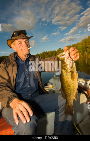 Angelführer hält einen Fisch in seinem Boot in Nordontario. Stockfoto