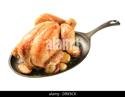 Gebackenes Huhn und Kartoffeln auf einer gusseisernen Pfanne Stockfoto