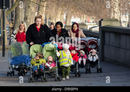 Junge Mütter gehen am Themse-Ufer an einem Wochentag Morgen London England Vereinigtes Königreich UK Stockfoto