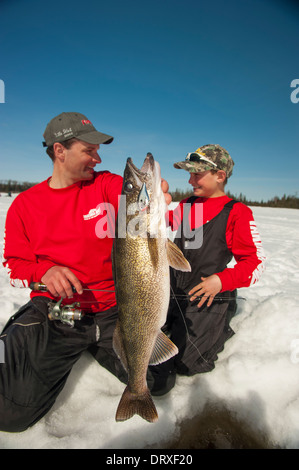 Vater und Sohn halten eine Winter-Zander, dass sie Eisangeln gefangen. Stockfoto