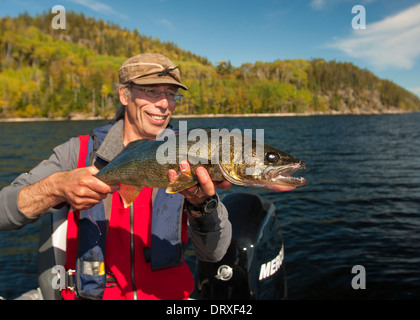 Angler hält eine große Sommer-Zander, die er von seinem Boot auf einem See im Norden von Ontario gefangen. Stockfoto