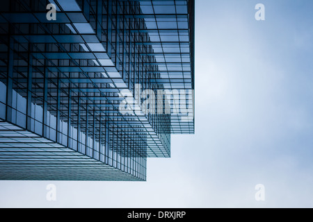 Ein hoher Wolkenkratzer erreicht in den Himmel. Es ist vielen Fenstern das blaue Licht zu reflektieren. Stockfoto