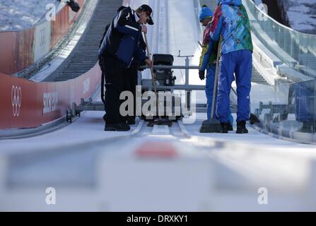 Arbeiter bereiten die Skipisten von Ski-Sprung-Hang des Hügels am RusSki Gorki Jumping Center an der 2014 Olympischen Spiele in Sotschi, Sotschi, Russland, 4. Februar 2014. Die Olympischen Winterspiele 2014 in Sotschi von 07 bis 23. Februar 2014 laufen. Foto: Kay Nietfeld/dpa Stockfoto