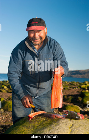 Eine Inuit-Angelführer Filets das gefangenen Fische-Fliegenfischen in den arktischen Gewässern. Stockfoto