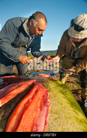 Eine Inuit-Angelführer Filets das gefangenen Fische-Fliegenfischen in den arktischen Gewässern. Stockfoto